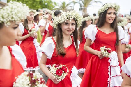 women dressed in colorful clothes at the Festa da Flor or Spring Flower Festival in the city of Funchal on the Island of Madeira in the Atlantic Ocean of Portugal.  Madeira, Funchal, April, 2018のeditorial素材