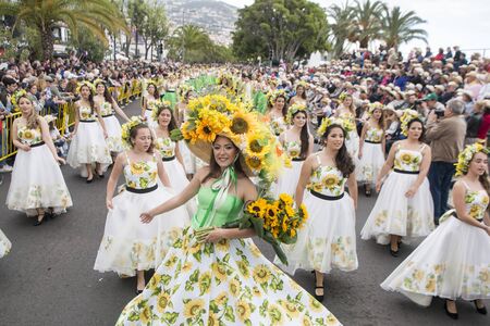 women dressed in colorful clothes at the Festa da Flor or Spring Flower Festival in the city of Funchal on the Island of Madeira in the Atlantic Ocean of Portugal.  Madeira, Funchal, April, 2018のeditorial素材