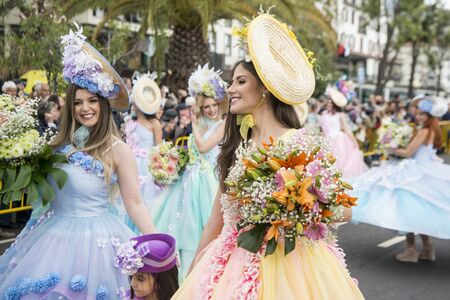 women dressed in colorful clothes at the Festa da Flor or Spring Flower Festival in the city of Funchal on the Island of Madeira in the Atlantic Ocean of Portugal.  Madeira, Funchal, April, 2018のeditorial素材