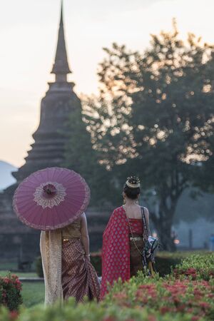 women in traditional dress at the Wat Mahathat Temple at the Historical Park in Sukhothai in the Provinz Sukhothai in Thailand.   Thailand, Sukhothai, November, 2018のeditorial素材
