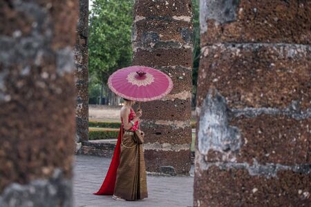 women in traditional dress at the Wat Mahathat Temple at the Historical Park in Sukhothai in the Provinz Sukhothai in Thailand.   Thailand, Sukhothai, November, 2018のeditorial素材