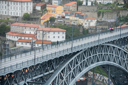 the Ponte de Dom Luis 1 by rain shower at the old town on the Douro River in Ribeira in the city...