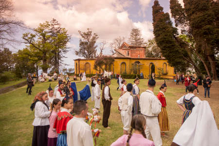 People in traditional dress in front of the Quinta Jardins do Imperador on the reopening of the Emperior Gardens at Monte near the city centre of Funchal on the Island Madeira of Portugal.   Portugal, Madeira, April 2018のeditorial素材