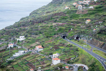 a highway at a village with the agriculture and landscape at the town of Ponta do Sol, west of Funchal on the Island Madeira of Portugal.   Portugal, Madeira, April 2018のeditorial素材