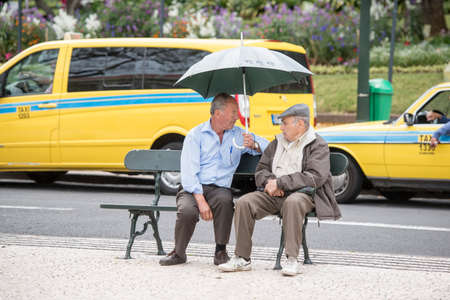 seniors at the avenida Arriaga in front of Taxi cars in the city centre of Funchal on the Island Madeira of Portugal.   Portugal, Madeira, April 2018のeditorial素材