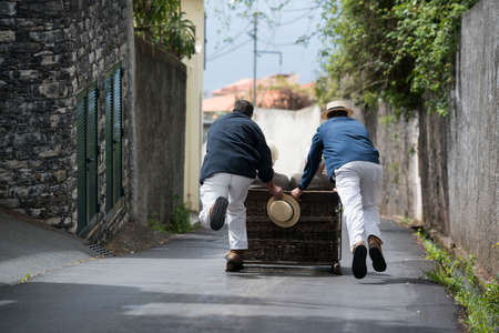 a traditional Monte sledge on the way from Monte to Funchal the city centre of Funchal on the Island Madeira of Portugal.   Portugal, Madeira, April 2018のeditorial素材