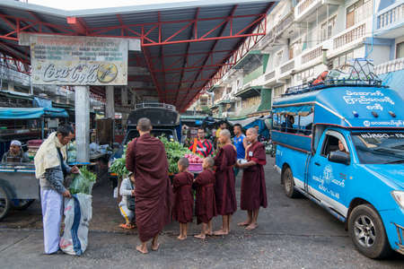 monks in the morning at the market in the marketstreet in the old Town of Mae Sot in the Province of Tak in Tahiland.   Thailand, Mae Sot, November, 2019のeditorial素材