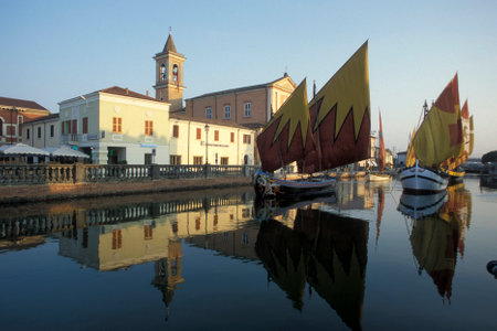 traditional fishing boats at the canale porto with the church of Saint James in the town of Cesenatico in Emilia-Romagna in Italy.   Italy, Cesenatico, June, 2001のeditorial素材