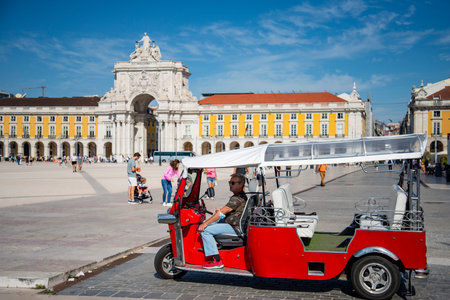 a tuk Tuk with the arco da Rua Augusta at the Parca do Comercio in Baixa in the City of Lisbon in...