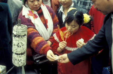 a shop sells sweets at a street market in the City of Kaifeng in the Province of Henan in China. China, Kaifeng, November, 1996のeditorial素材