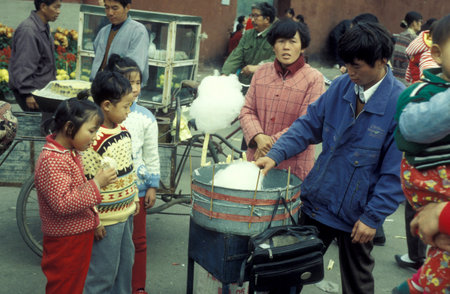 a shop sells sweets at a street market in the City of Kaifeng in the Province of Henan in China. China, Kaifeng, November, 1996のeditorial素材