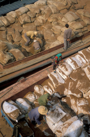 Worker offload Sand for Construction off a Transport ship at the Ganjiang River in the City of Nanchang in the Province of Jiangxi in China. China, Nanchang, November, 1996のeditorial素材