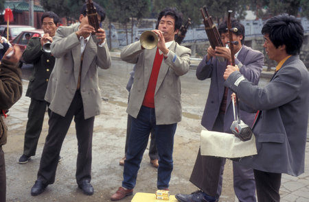 people play music at a park in the City of Kaifeng in the Province of Henan in China. China, Kaifeng, November, 1996のeditorial素材