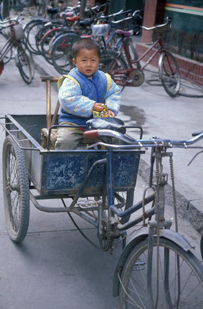 a Boy on a Bicycle Riksha in the City of Nanchang in the Province of Jiangxi in China. China, Nanchang, November, 1996のeditorial素材