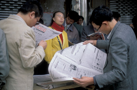 People with Newspapers at the Stockmarket in the City of Nanchang in the Province of Jiangxi in China. China, Nanchang, November, 1996のeditorial素材