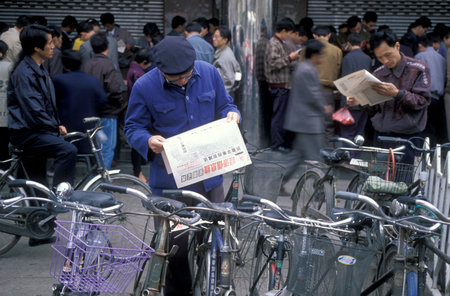 People with Newspapers at the Stock Market in the City of Nanchang in the Province of Jiangxi in China. China, Nanchang, November, 1996のeditorial素材