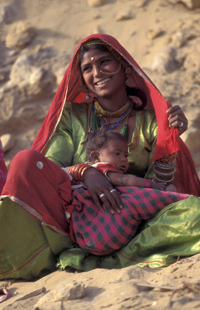 a portrait of a Rajasthani woman with her baby in the Town of Jaisalmer in the Province of Rajasthan...