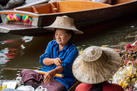 a women sells fruits on her woodboat at Damnoen Saduak Floating market in Province of Ratchaburi in Thailand, Thailand, Ratchaburi, November, 12, 2023のeditorial素材