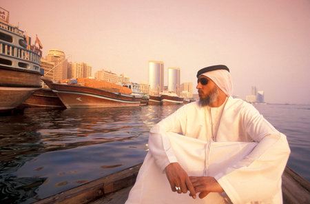 An Arab men on a Tour at a Taxi Boat on Dubai Creek in old town in the city of Dubai in UAE. Dubai, October 4, 2004のeditorial素材