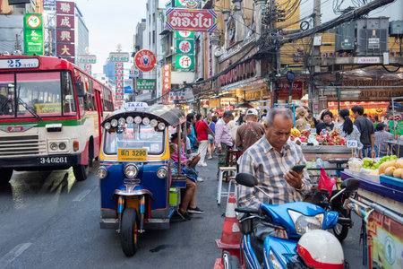 People and Tuk Tuk at Marketstreet on Yaowarat Road in Chinatown in City of Bangkok in Thailand....
