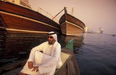 An Arab men on a Tour at a Taxi Boat on Dubai Creek in old town in the city of Dubai in UAE. Dubai,...