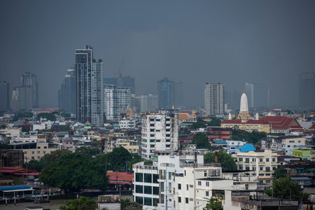 Chedi of Wat Phitchayatikaram Worawihan in Thonburi with skyline of City of Bangkok in Thailand....