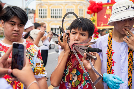 Ma-Song People with face pierced by steel skewers during at spirit ceremony and parade at Phuket...