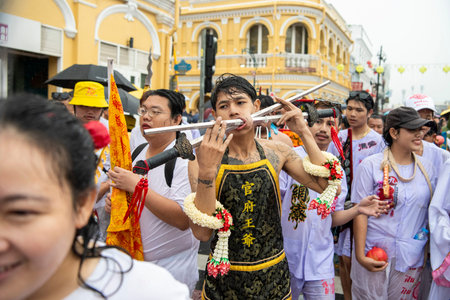 Ma-Song People with face pierced by steel skewers during at spirit ceremony and parade at Phuket...