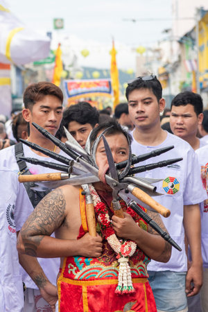 Ma-Song People with face pierced by steel skewers during at spirit ceremony and parade at Phuket...