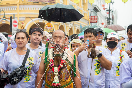 Ma-Song People with face pierced by steel skewers during at spirit ceremony and parade at Phuket Vegetarian Festival in Phuket City in Thailand. Thailand, Phuket, October 25, 2025のeditorial素材