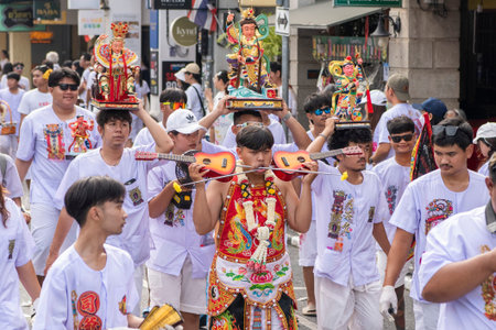 Ma-Song People with face pierced by steel skewers during at spirit ceremony and parade at Phuket...