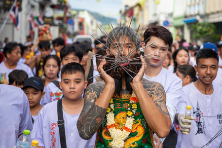 Ma-Song People with face pierced by steel skewers during at spirit ceremony and parade at Phuket...