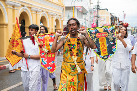 Ma-Song People with face pierced by steel skewers during at spirit ceremony and parade at Phuket...