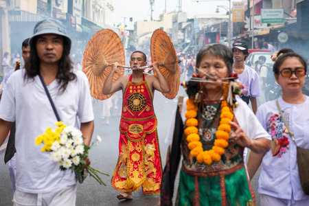 Ma-Song People with face pierced by steel skewers during at spirit ceremony and parade at Phuket...