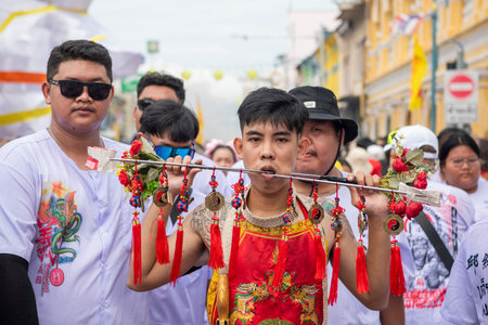 Ma-Song People with face pierced by steel skewers during at spirit ceremony and parade at Phuket...