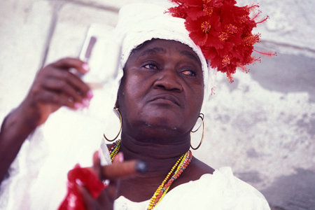 A Cuban woman smokes a Cuban cigar in the city of Havana on Cuba in the Caribbean Sea. Cuba, Havana,...