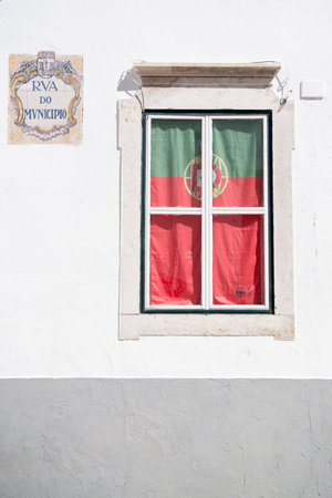 the portugese flag at a window in the old town of Faro at the east Algarve in the south of Portugal...
