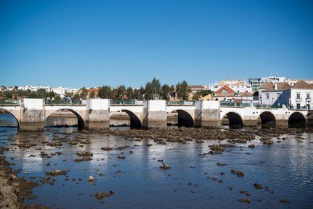 The Bridge Ponte Romana in the old town of Tavira at the east Algarve in the south of Portugal in...
