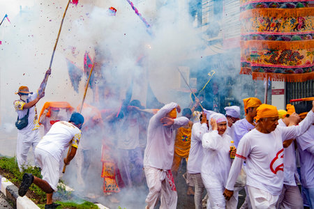 Firecrackers erupt around Devotees which carry a litter housing a Taoist god idol during a spirit Parade at Phuket City Vegetarian Festival in Thailand. Thailand, Phuket, October, 22, 2025のeditorial素材