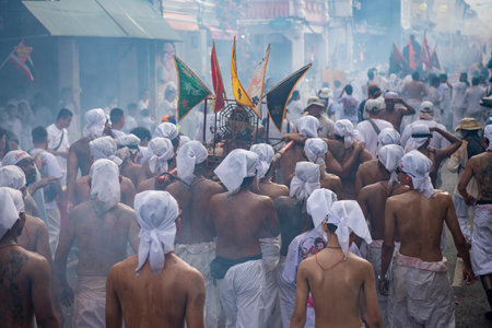 Devotees carry a litter housing a Taoist god idol during at spirit ceremony and Parade at Phuket...