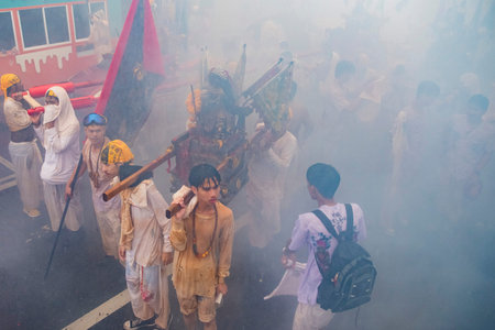Firecrackers erupt around Devotees which carry a litter housing a Taoist god idol during a spirit Parade at Phuket City Vegetarian Festival in Thailand. Thailand, Phuket, October, 25, 2025のeditorial素材