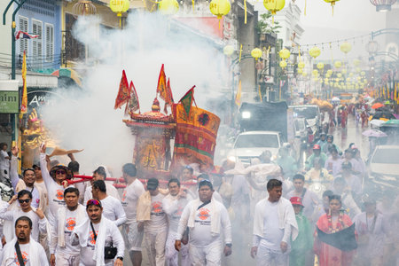 Firecrackers erupt around Devotees which carry a litter housing a Taoist god idol during a spirit...
