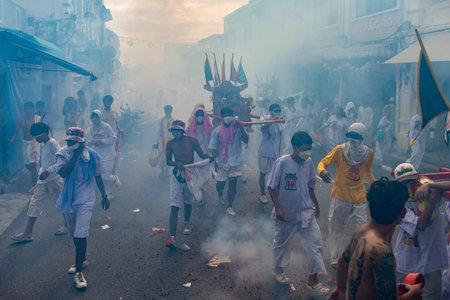 Firecrackers erupt around Devotees which carry a litter housing a Taoist god idol during a spirit...