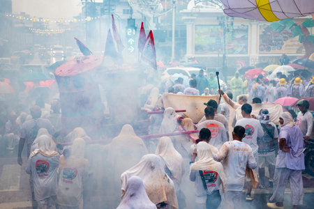 Firecrackers erupt around Devotees which carry a litter housing a Taoist god idol during a spirit...