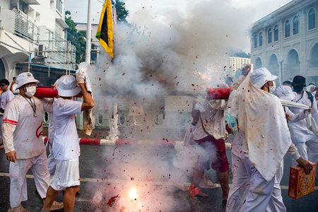 Firecrackers erupt around Devotees which carry a litter housing a Taoist god idol during a spirit...
