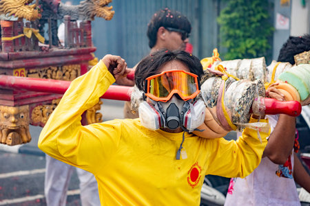 Devotees carry a litter housing a Taoist god idol during at spirit ceremony and Parade at Phuket...