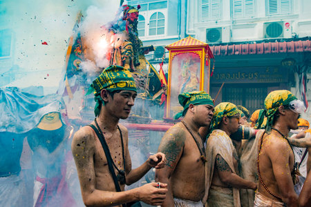 Firecrackers erupt around Devotees which carry a litter housing a Taoist god idol during a spirit...
