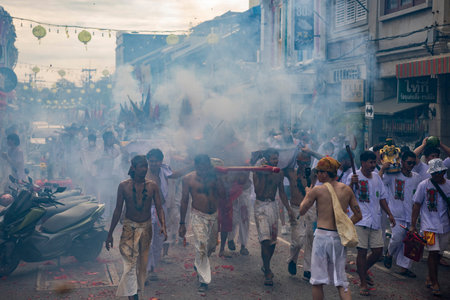 Firecrackers erupt around Devotees which carry a litter housing a Taoist god idol during a spirit Parade at Phuket City Vegetarian Festival in Thailand. Thailand, Phuket, October, 26, 2025のeditorial素材