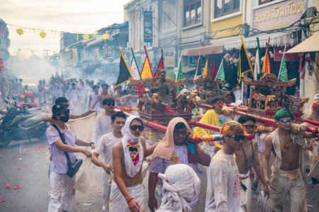 Firecrackers erupt around Devotees which carry a litter housing a Taoist god idol during a spirit...