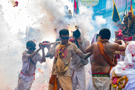 Firecrackers erupt around Devotees which carry a litter housing a Taoist god idol during a spirit...